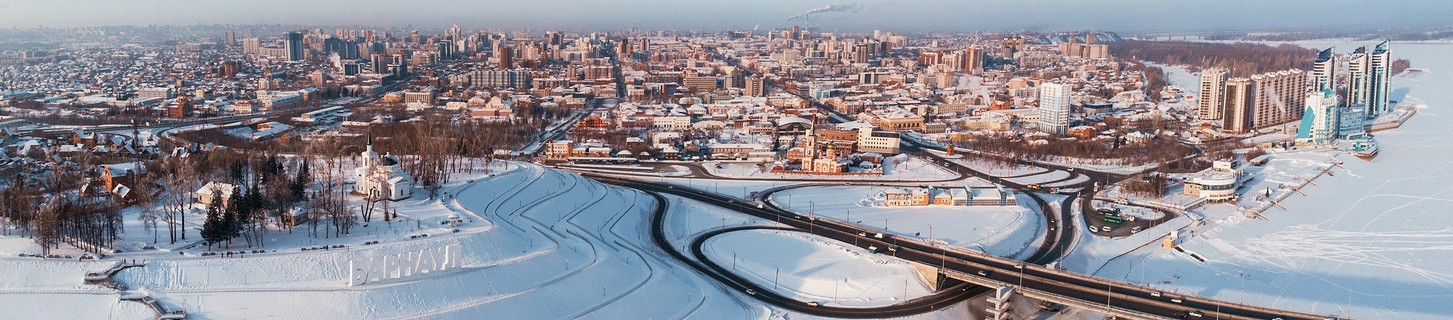 Аэрофотосъемка моста и автомобиля по мосту, зимний солнечный день в Барнауле