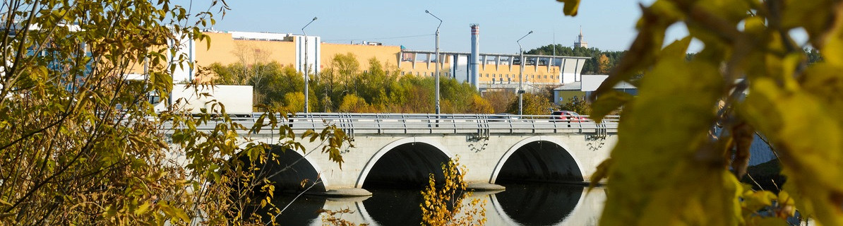 Вид с берега на современный арочный мост через реку Миасс