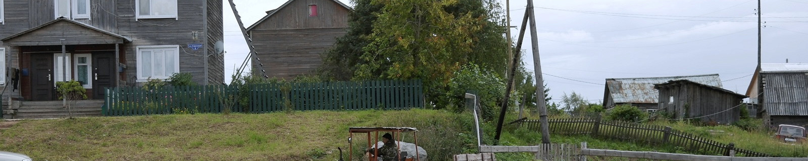Трактор с прицепом едет по дороге в сельской местности. Деревня Ломоносово, Россия