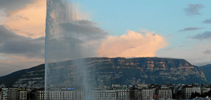 Вид на фонтан Jet d'eau и горы в вечернее время, Женева