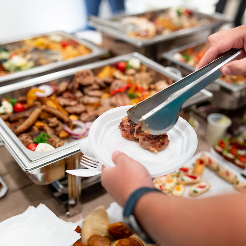 человек выбирает блюда на шведском столе в отеле