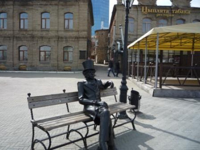 Скульптура горожанина на лавочке между театром и фонтаном.