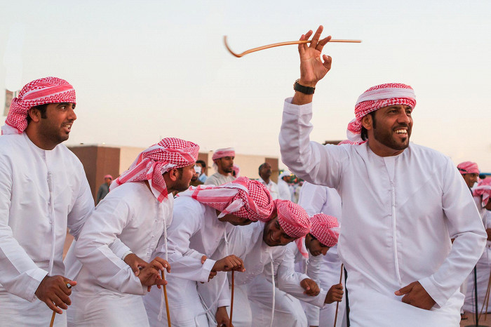 Мужчины исполняют традиционный танец Явала на фестивале Аль-Дафра