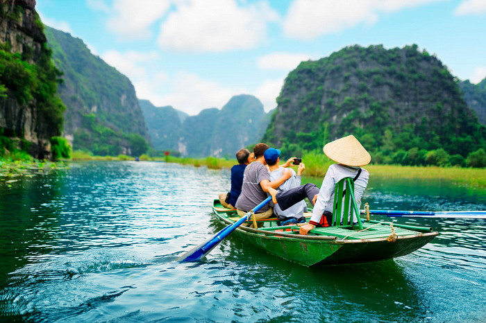 Туристы путешествуют на лодке вдоль реки Нго-Донг