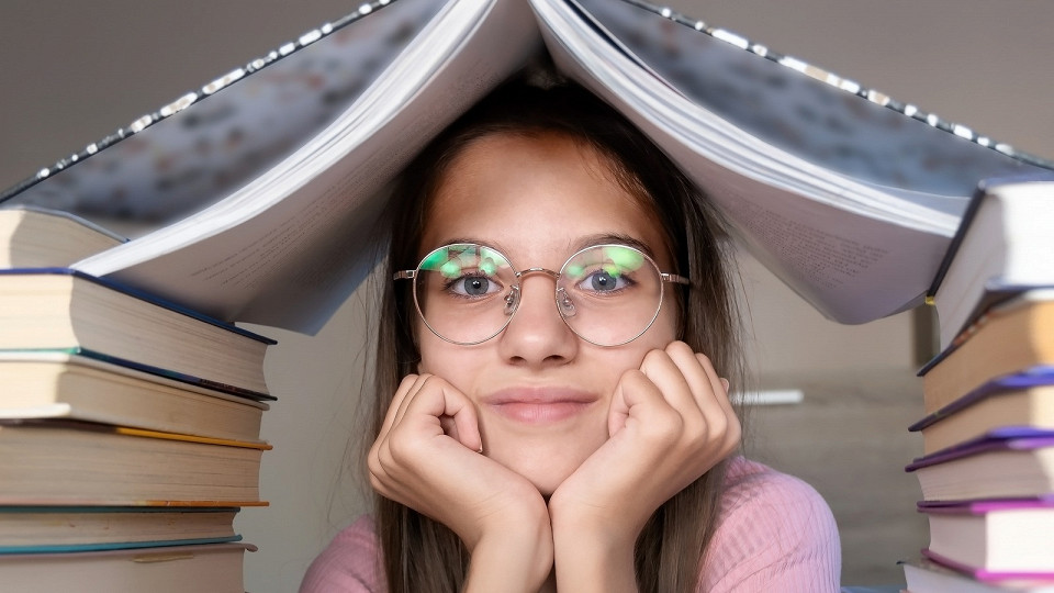 Девочка в очках с книгами