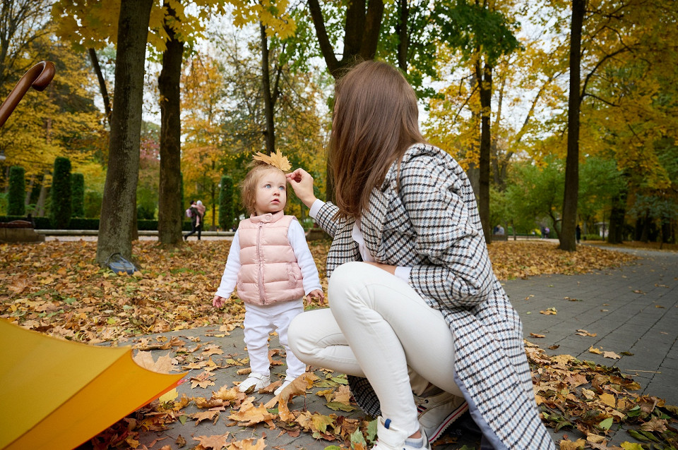 Мать и дочь гуляют в осеннем парке