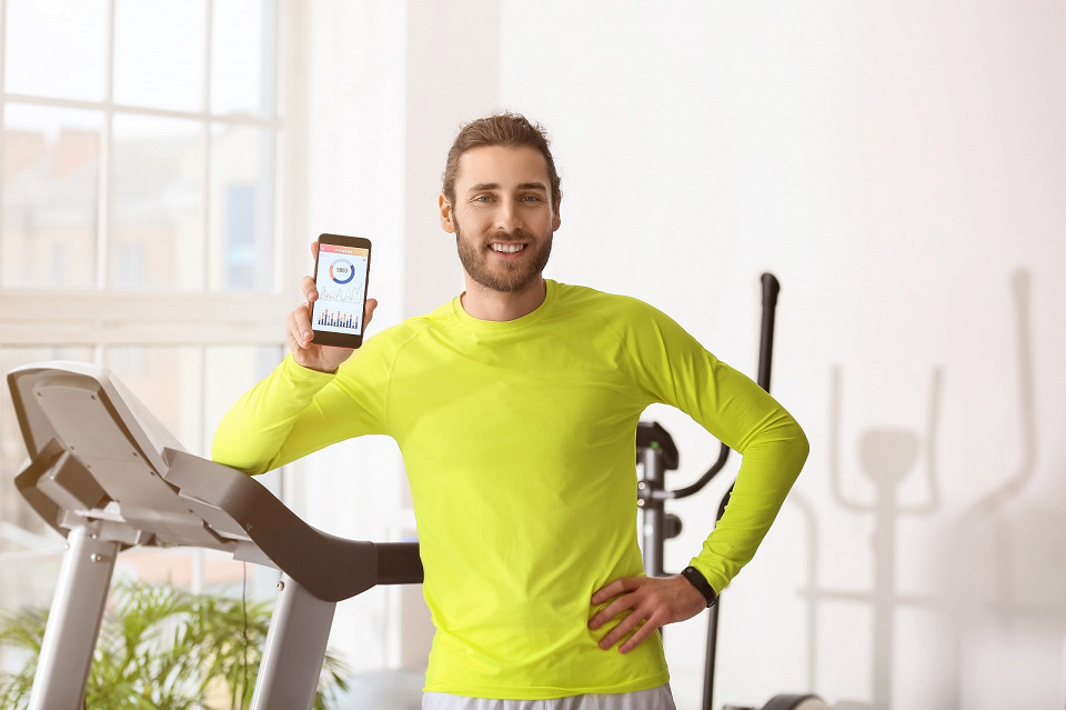 Мужична в спортзале с телефон, шагомер