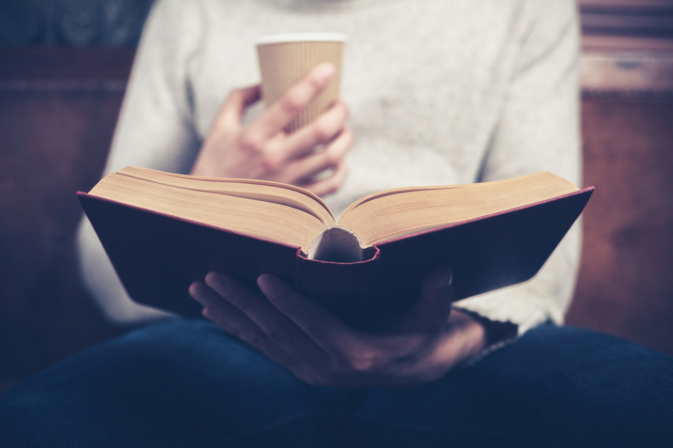 Мужчина читает толстую книгу