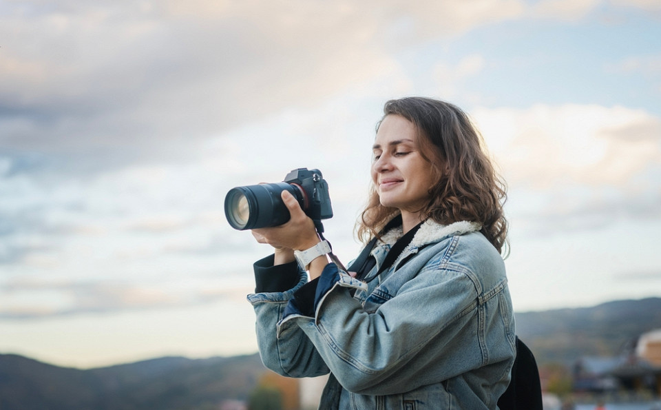 Девушка с фотоаппаратом улыбается