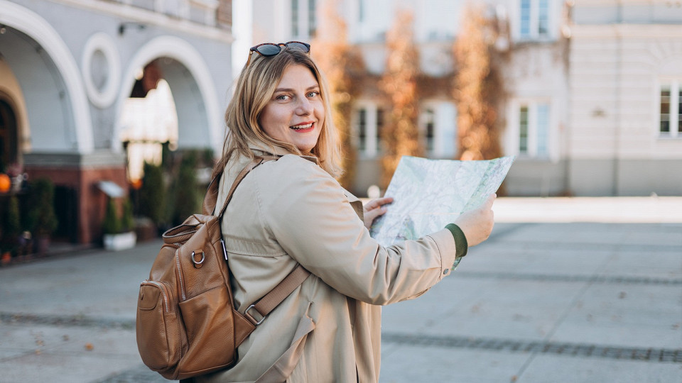 Девушка с рюкзаком и картой в городе