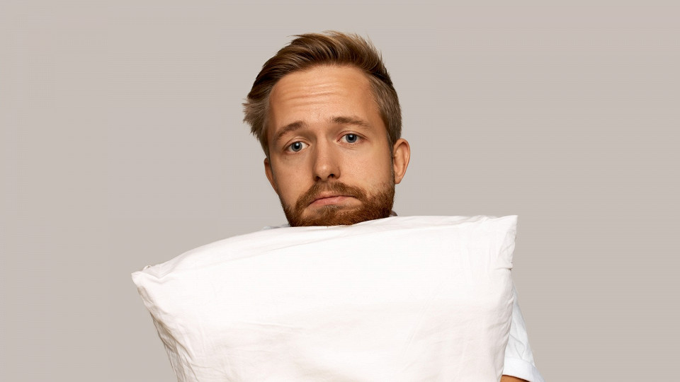 Грустный мужчина держит подушку