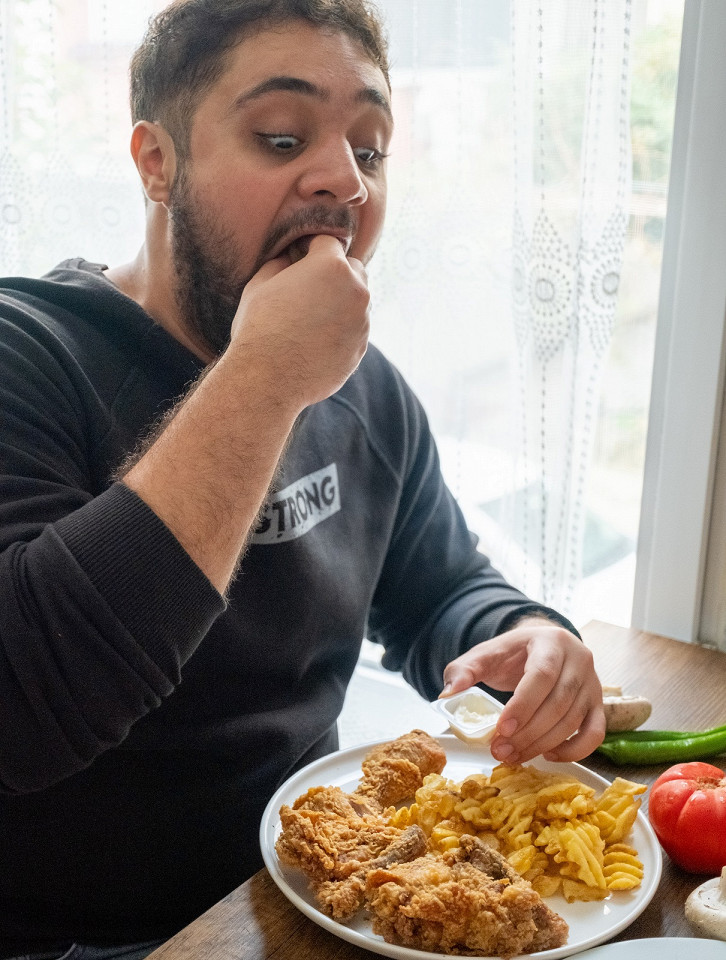 Обжора ест картошку фри пальцами