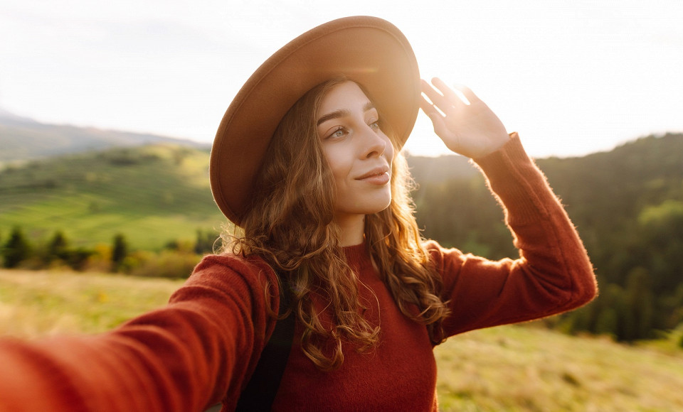 Девушка в шляпе делает селфи