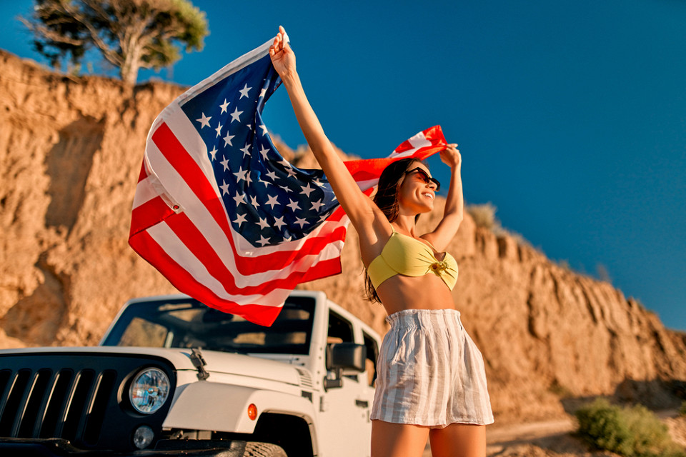 Девушка на фоне машины с флагом США